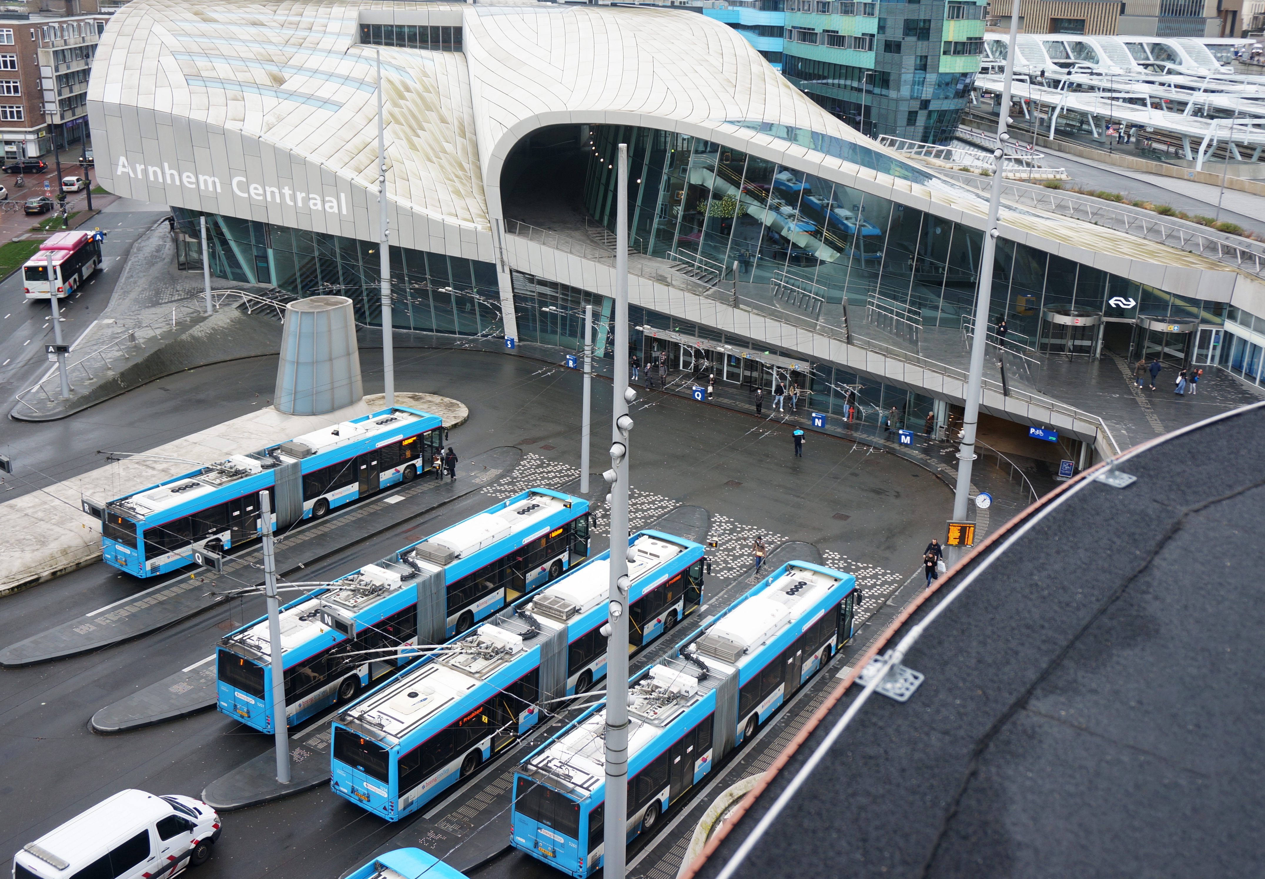 vier bussen wachten bij een bushalte naast het station
