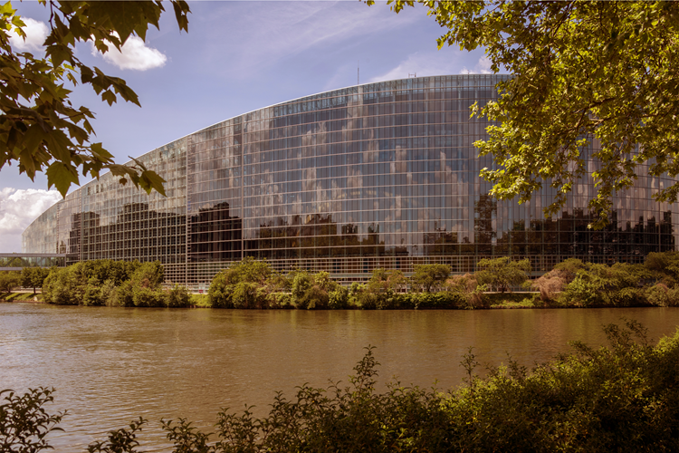 Het gebouw van het Europees Parlement met een vijver op de voorgrond