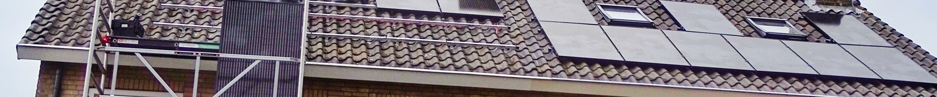 installateurs leggen zonnepanelen op het dak van een woning