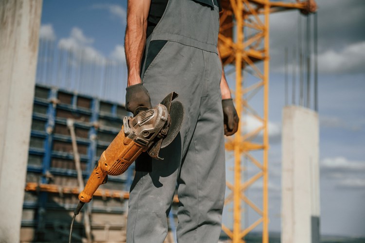 Holding Grinding Machine Man In Uniform Is Workin 2022 10 07 00 16 28 Utc