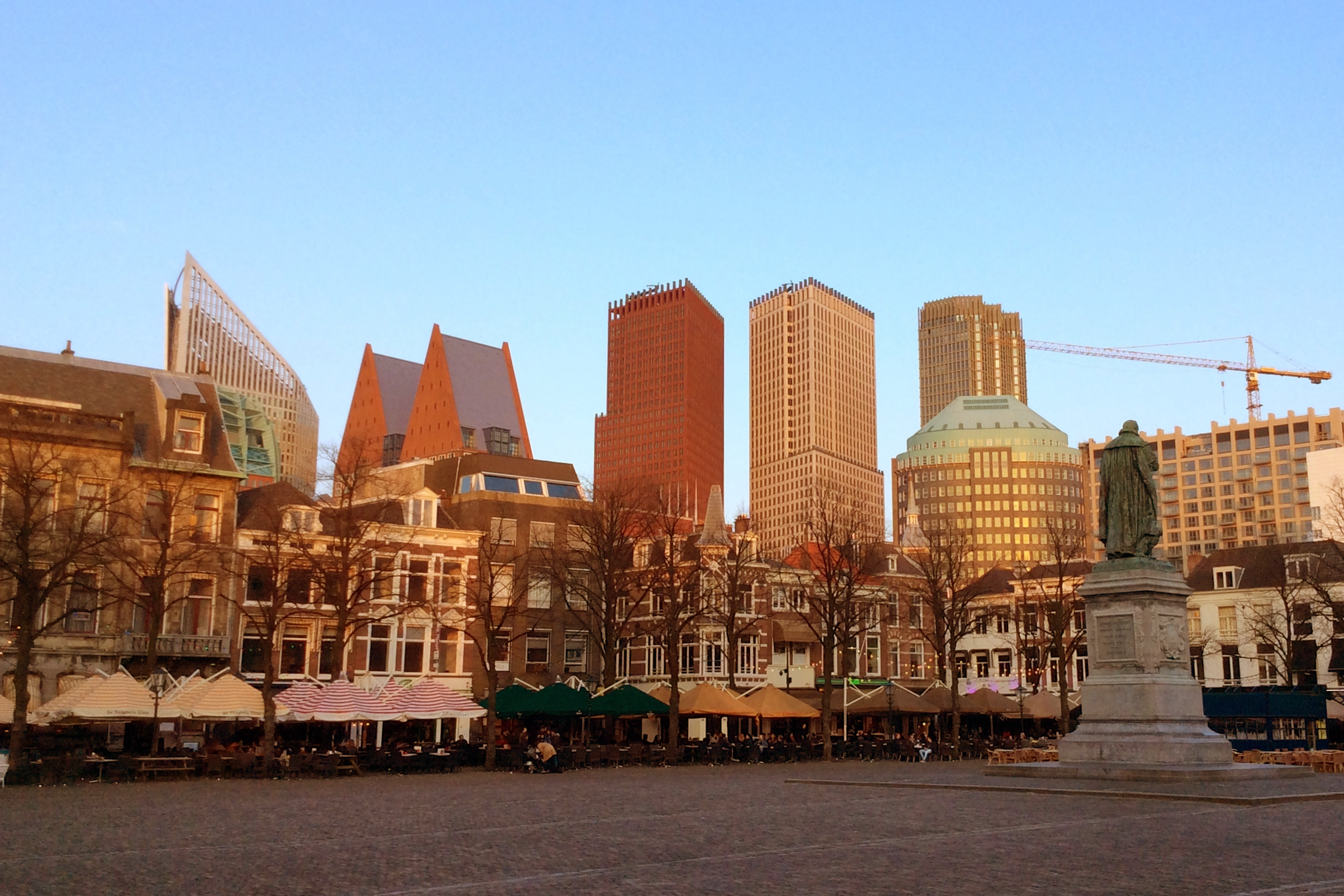 De skyline van Den Haag met een groot plein op de voorgrond tijdens zonsondergang