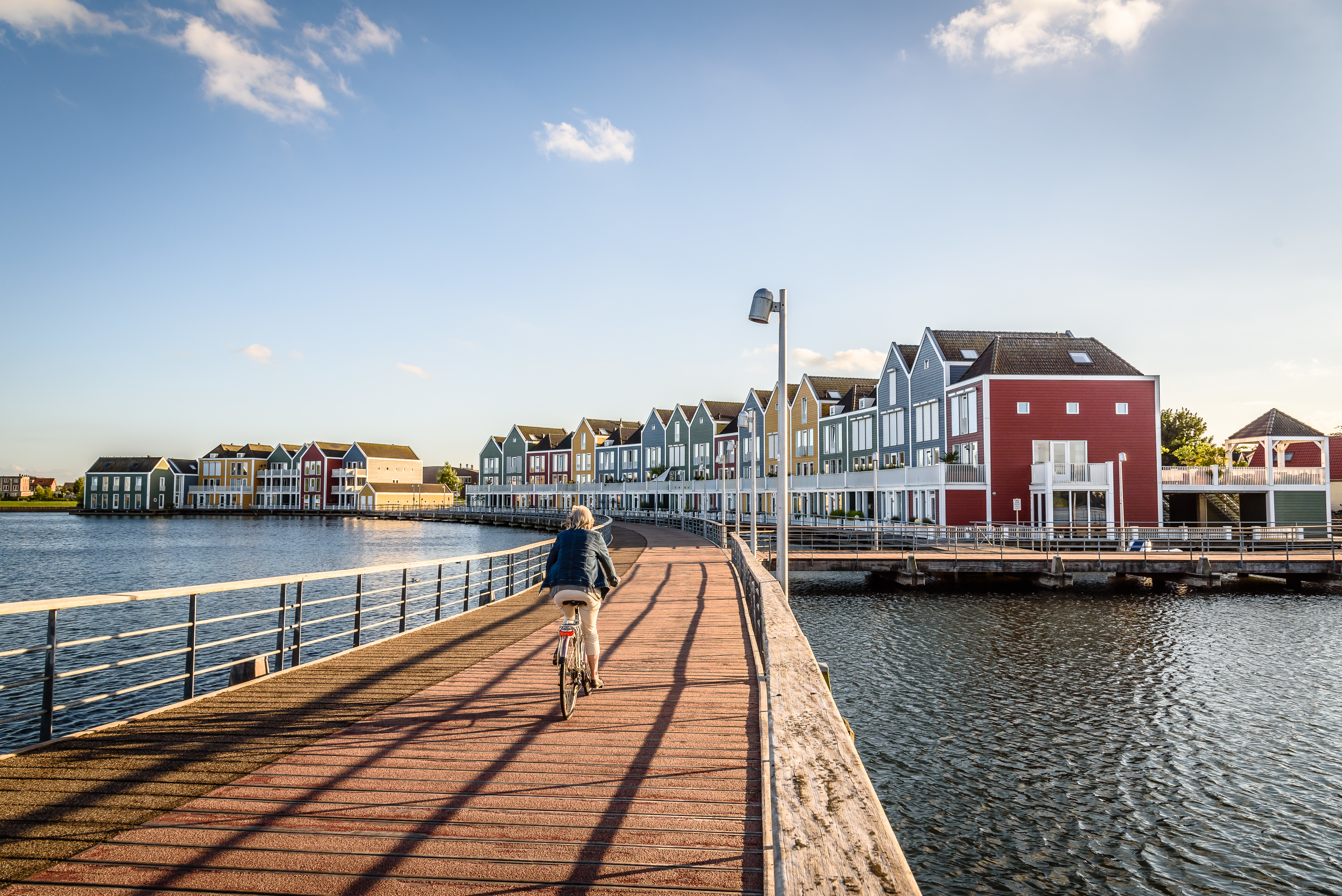 Fietser op een brug met huizen op de achtergrond