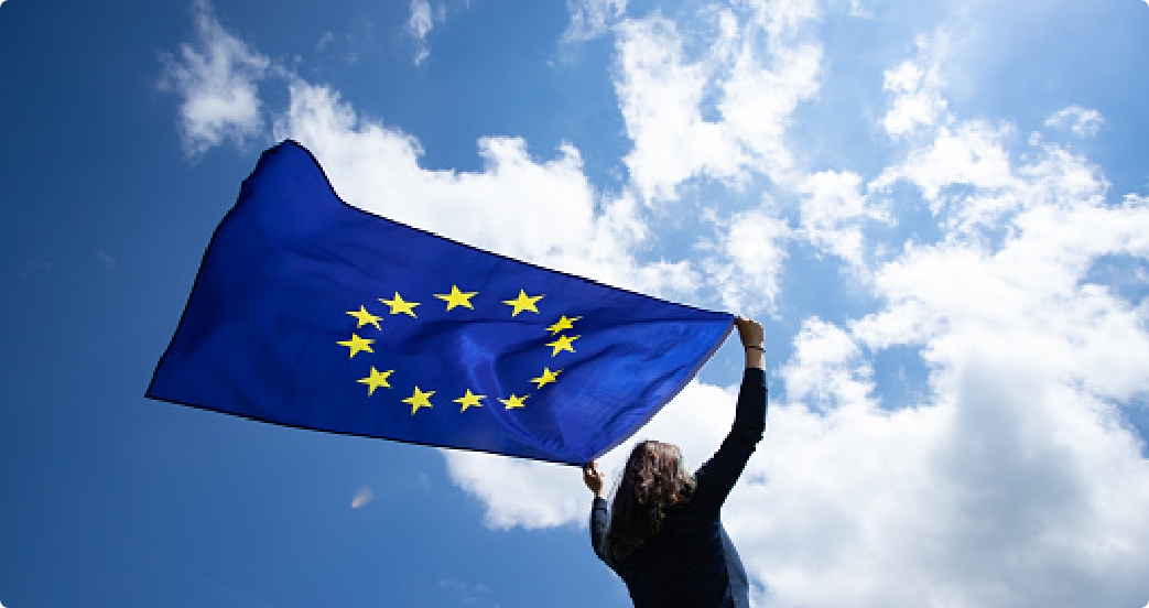 Een vrouw houdt de vlag van de Europese Unie boven haar hoofd